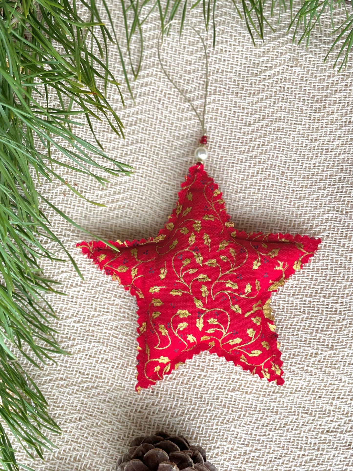 Red stuffed star Holiday tree decor handmade in Ireland using upcycled fabrics. Features a gold holly design.