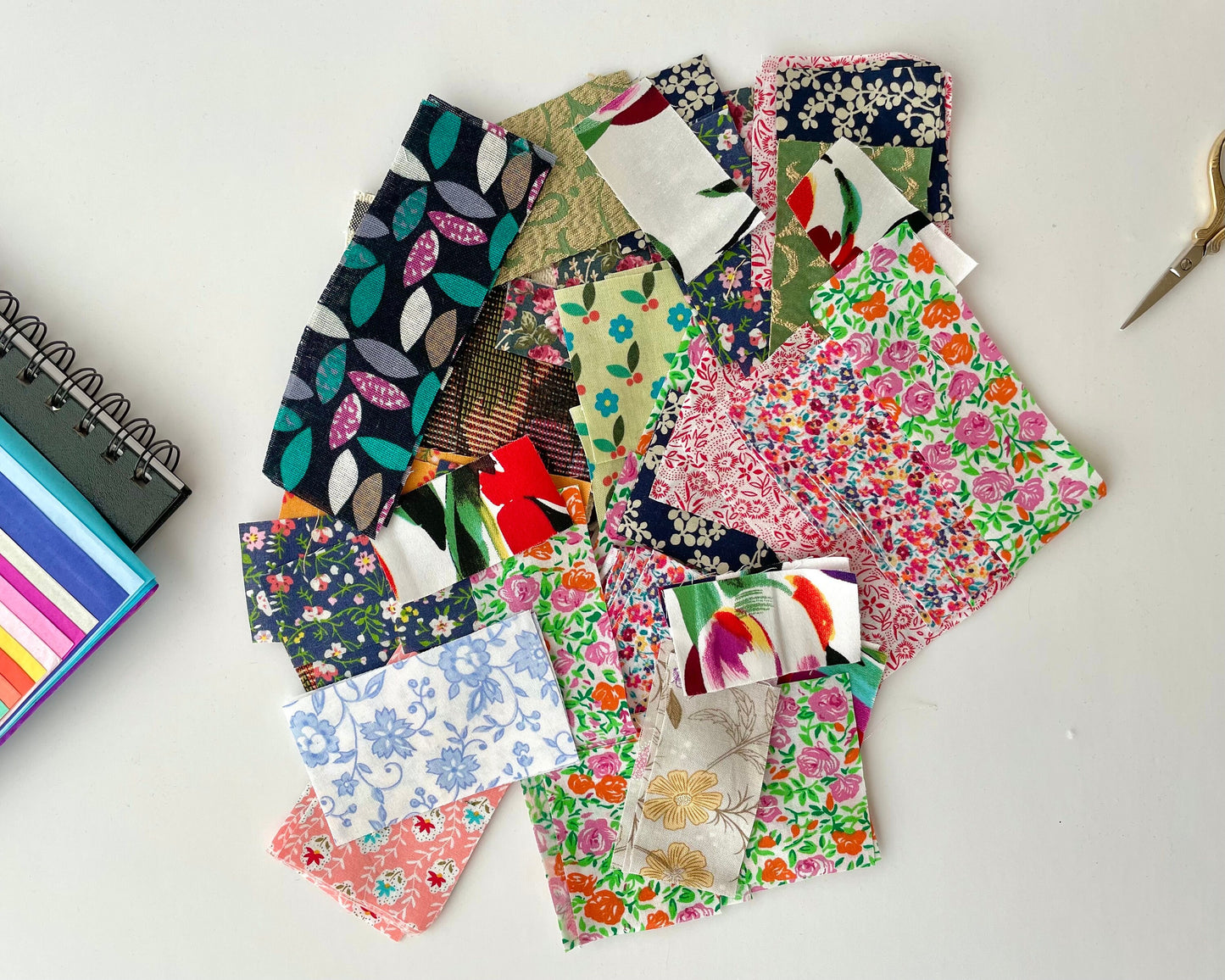 various Floral and botanical print fabric scraps for crafting in a mix of colours, cut into small rectangular shapes. Use for craft supplies, kids collages, slow stitching