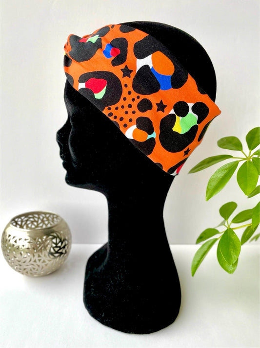 Handmade orange leopard print wide headband, adult size in cotton stretch fabric.