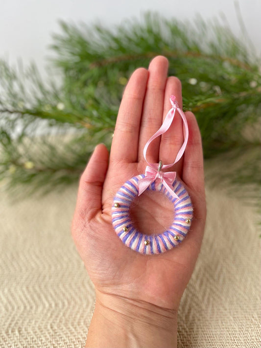 Pink and purple stripe wool upcycled Christmas ornament in the shape of a mini circular wreath. Features a pink bow and glass beads. Handmade in Ireland