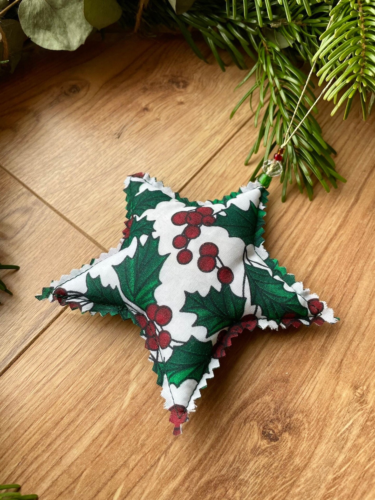 Star shape christmas ornament handmade in Ireland using holly patterned fabric and eco friendly upcycled fill.