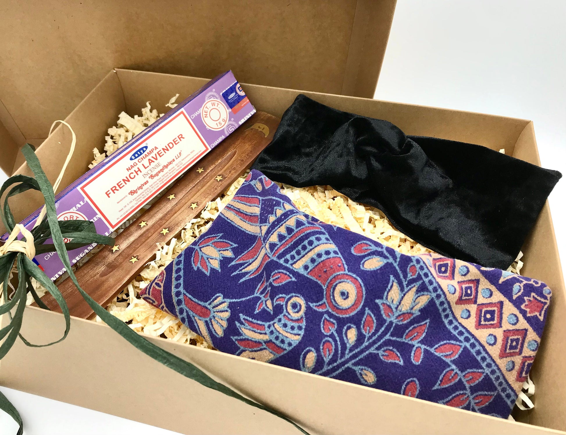 Self care gift set featuring an upcycled weighted eye pillow with a bird pattern, a black velour stretch headband and satya lavender incense and wooden incense holder