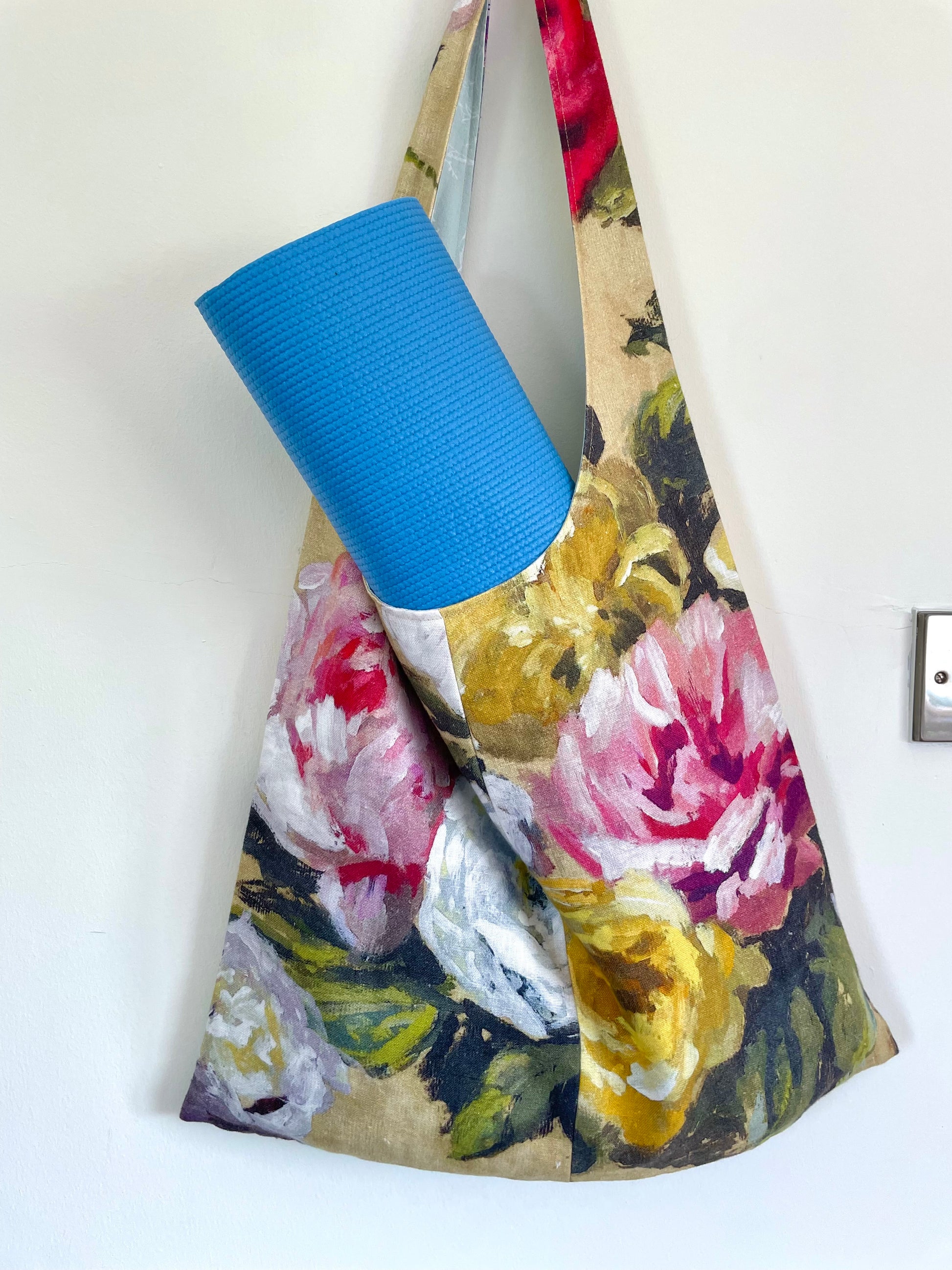 Pilates bag shown with yoga mat carried inside bag. Pilates bag handmade in Ireland using eco-friendly fabric in a floral design.
