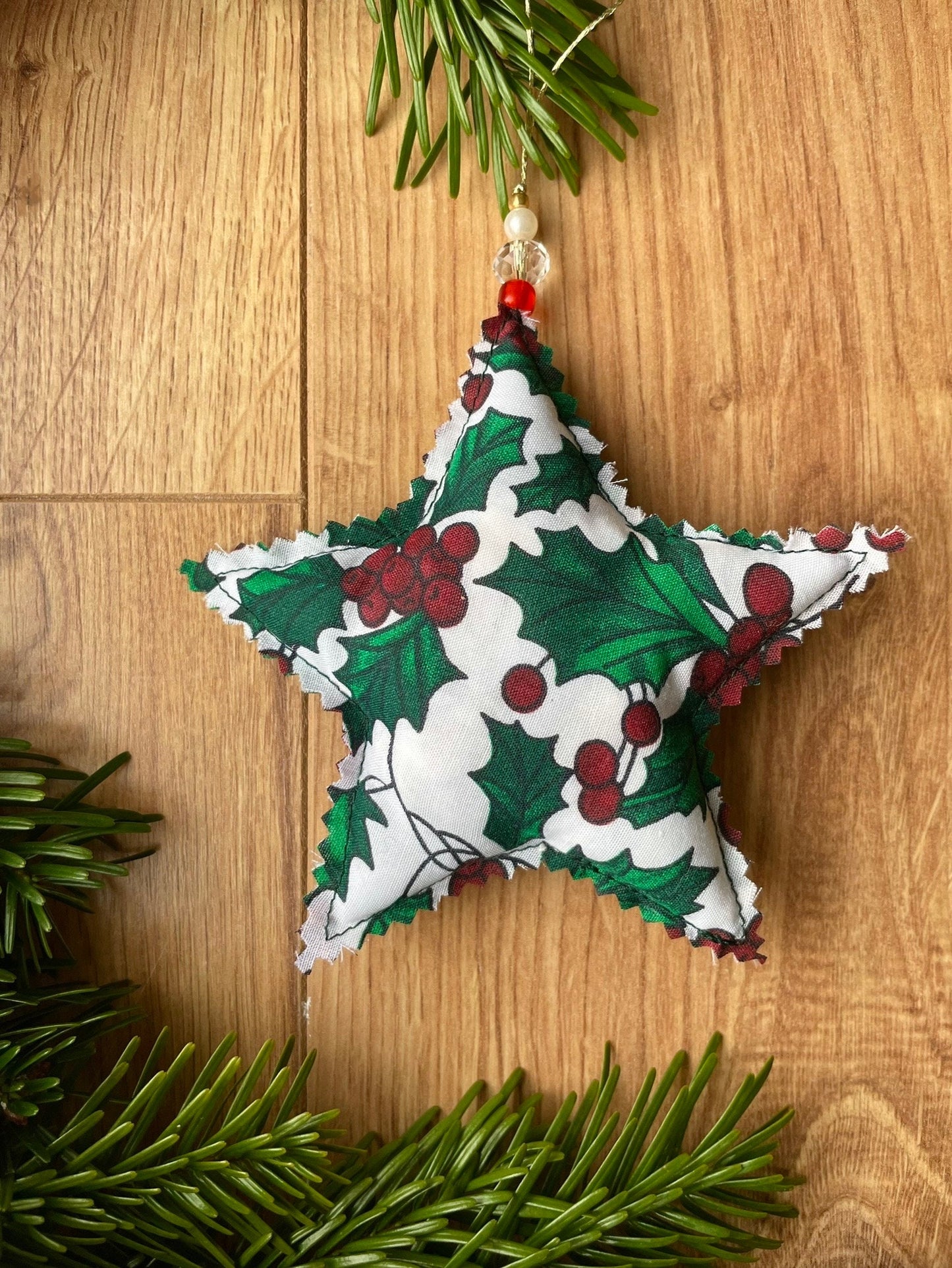 Holly pattern star shape fabric Christmas tree decoration, handmade in Ireland and completed with a series of beads at the top.