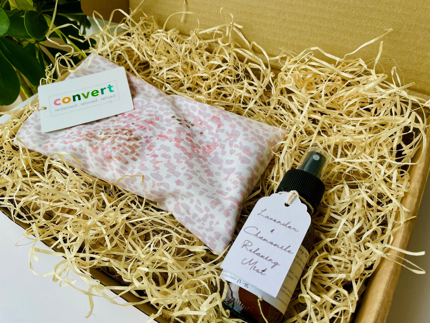 Relaxation and sleep gift hamper with an upcycled handmade weighted eye mask in a pink pattern and a bottle of lavender essential oil room pillow mist.